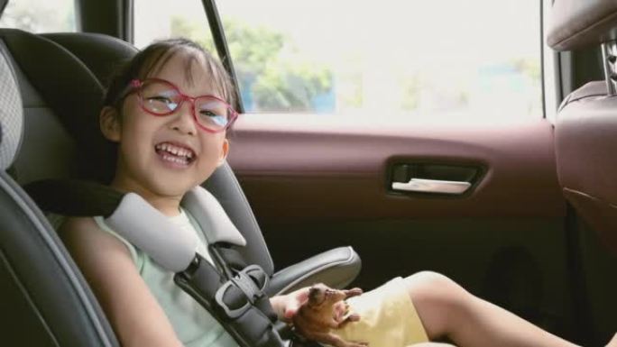 视频慢动作亚洲孩子在汽车上的汽车座椅。