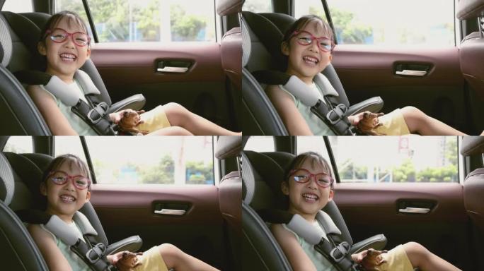视频慢动作亚洲孩子在汽车上的汽车座椅。
