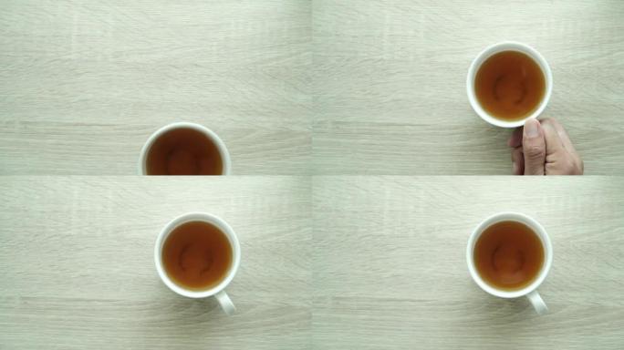 一个人的手在浅棕色的木桌上的白色茶杯中冲泡绿茶。俯视图，慢动作