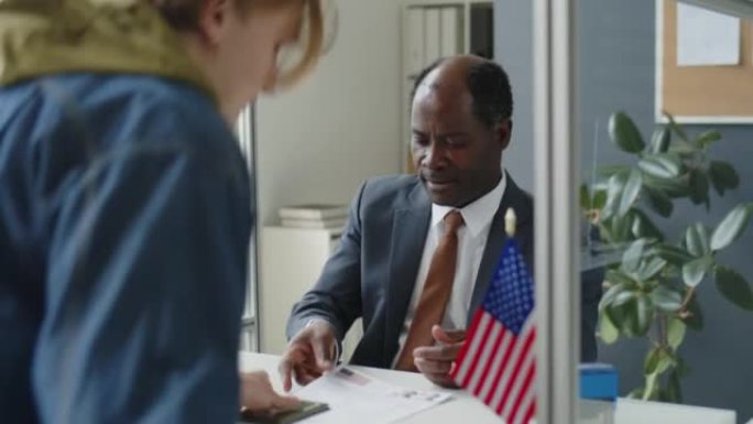 黑人签证官在美国大使馆与申请人一起工作