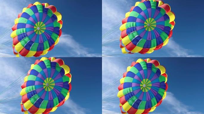 色彩鲜艳的降落伞在明亮的蓝天上。滑翔伞