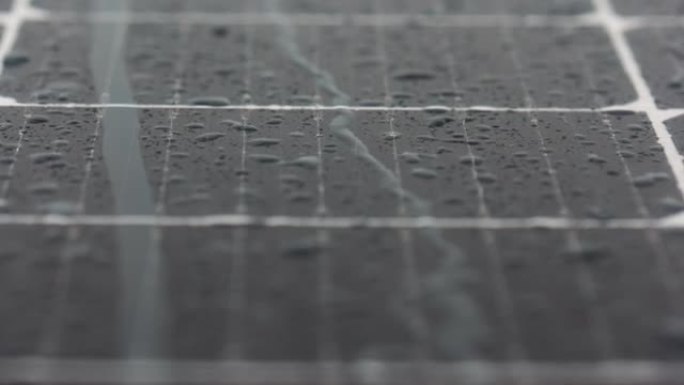 雨季的光伏太阳能电池板。细胞玻璃上的水滴