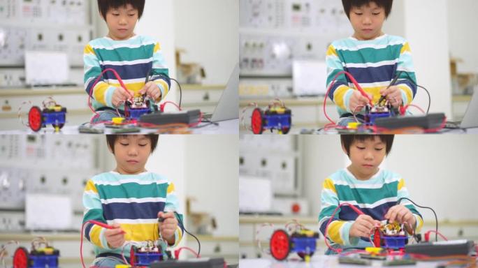 亚洲学生孩子使用电子仪表和笔记本电脑在科学课上建造自主自驱动机器人汽车的原型