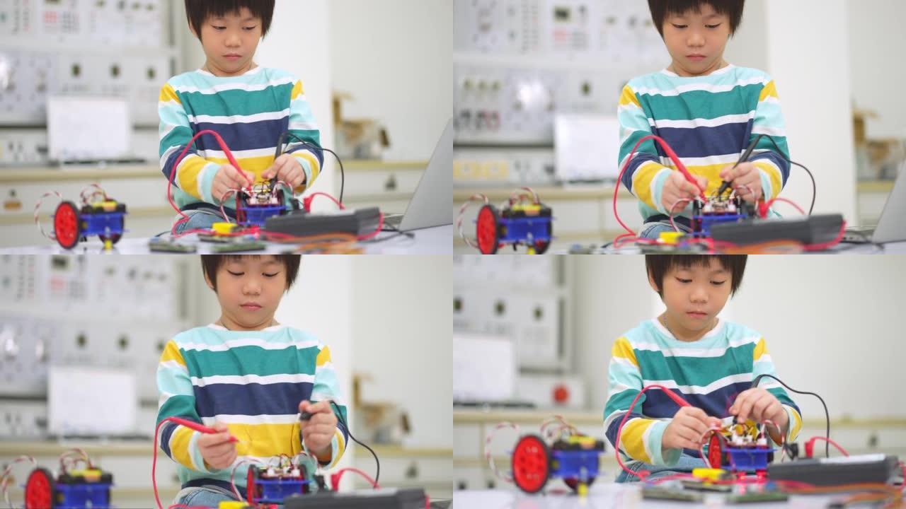 亚洲学生孩子使用电子仪表和笔记本电脑在科学课上建造自主自驱动机器人汽车的原型