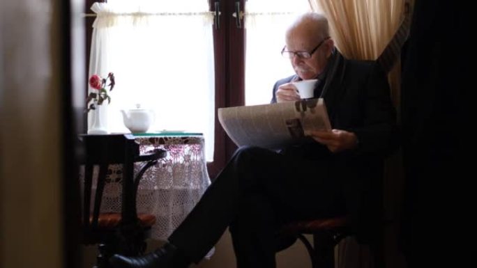 白发苍苍的爷爷正坐在咖啡馆里喝茶，他正在看报纸。