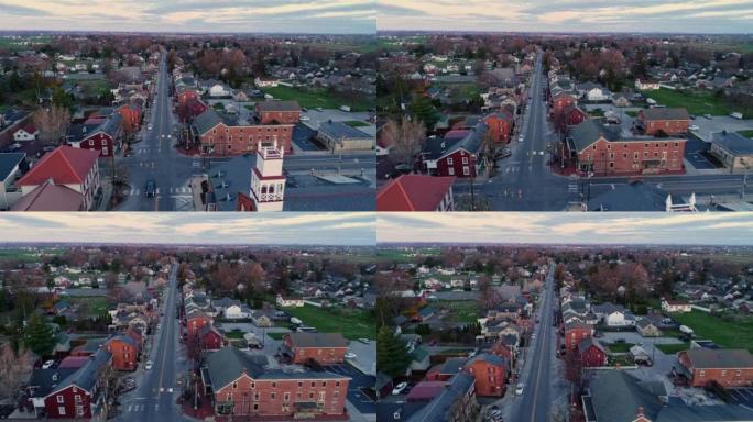 一个小镇和一个尖顶的鸟瞰图，当太阳升起在相机后面，并在春天的日出打破地平线时
