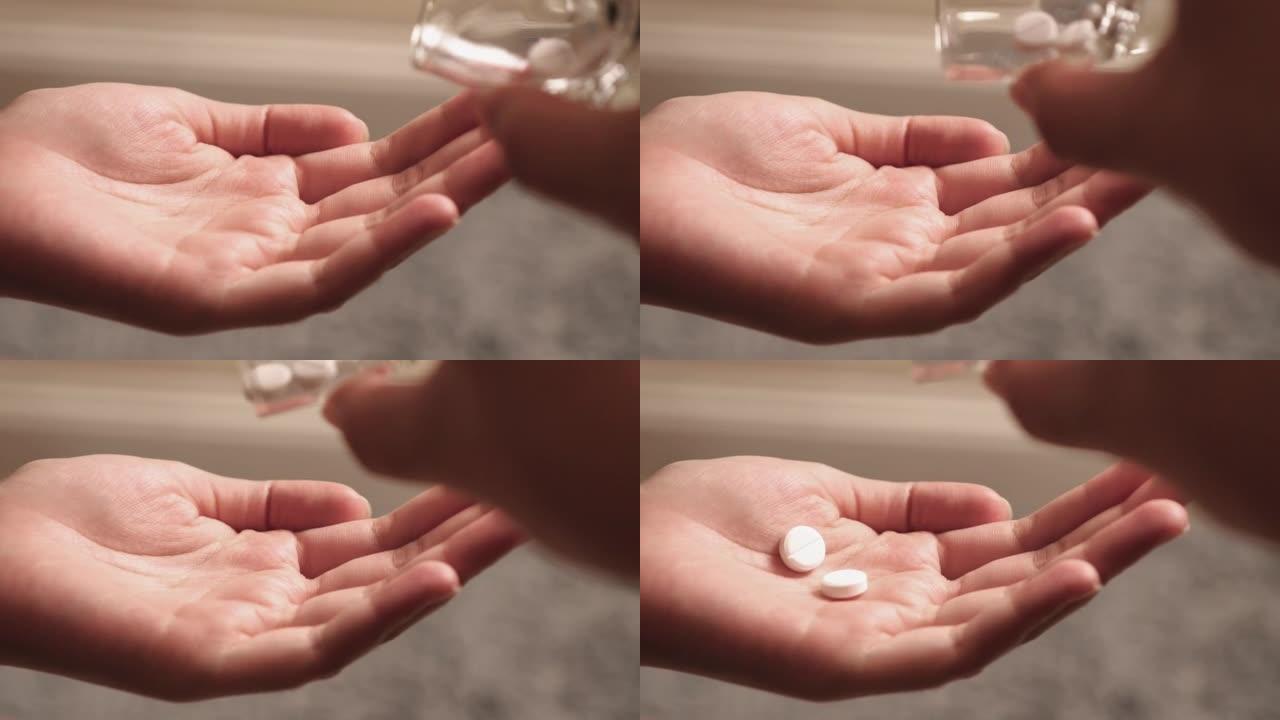 一个女人的手拿着白色止痛药慢动作的特写。
