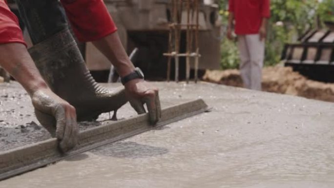 建筑工人在工地上建造找平层水泥地板。