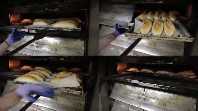 面包师从烤箱中拉出装有烤面包的托盘