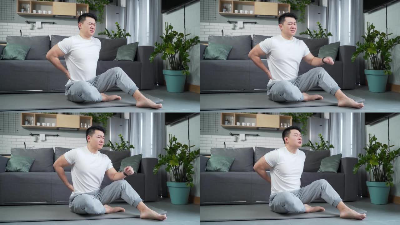 亚洲年轻人在室内锻炼伸展背部疼痛。运动健身男性痛苦感觉突然疼痛肩和关节肌肉劳损