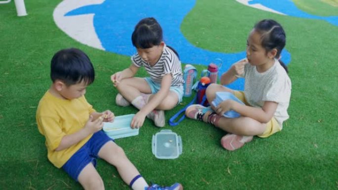 亚洲小孩在公园吃零食