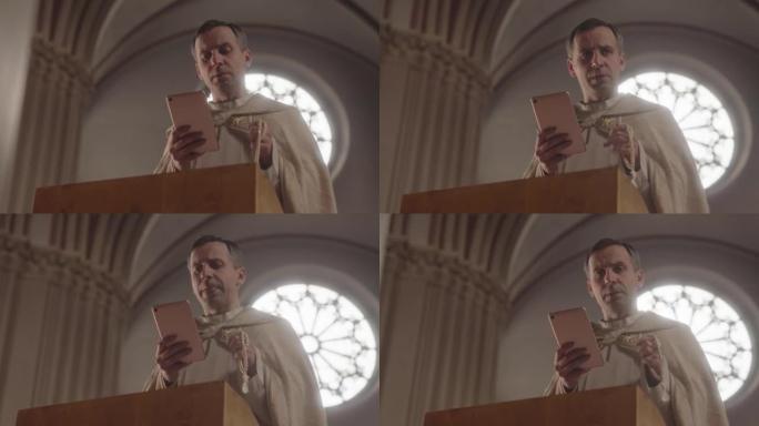 牧师在弥撒时用平板电脑读祷文