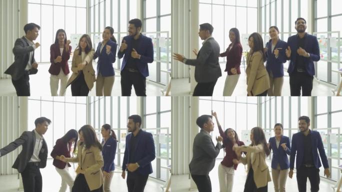 一群轻松愉快的亚洲商业团队员工在会议室办公室里玩得开心，做活动，跳舞。商业分析。人们的生活方式。庆祝