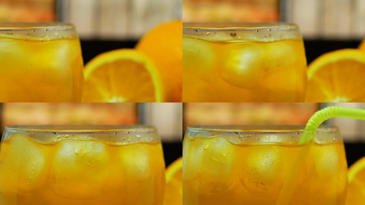 酒吧柜台上的特写鸡尾酒。冰冷鸡尾酒。透明玻璃杯中的黄色柠檬水。橙汁