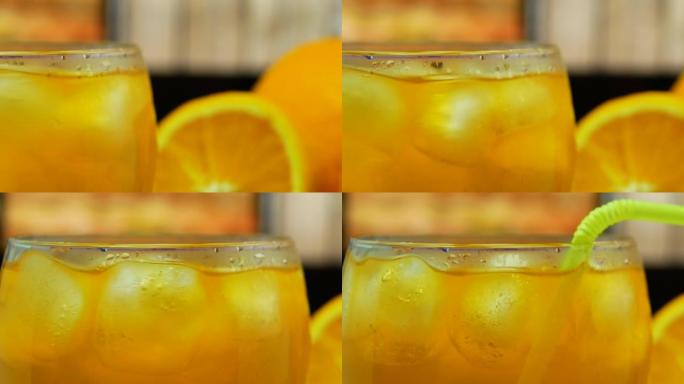 酒吧柜台上的特写鸡尾酒。冰冷鸡尾酒。透明玻璃杯中的黄色柠檬水。橙汁