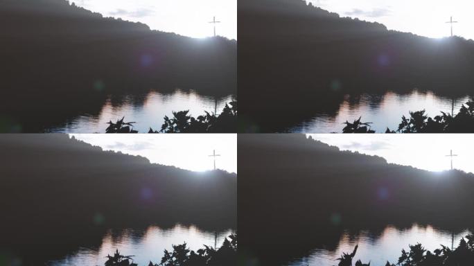 湖岸平静的湖水，耶稣基督神圣的十字架，以及明亮的光芒