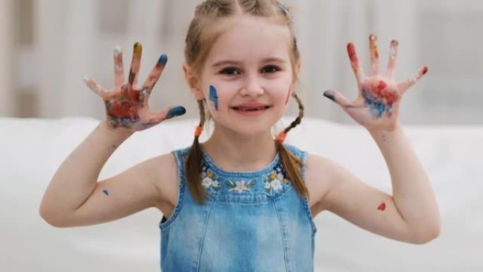 小女孩用油漆展示她的手