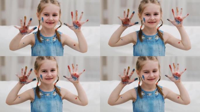 小女孩用油漆展示她的手