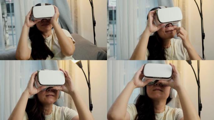 亚洲妈妈在家靠窗的沙发上通过虚拟现实玩游戏，科技生活理念。