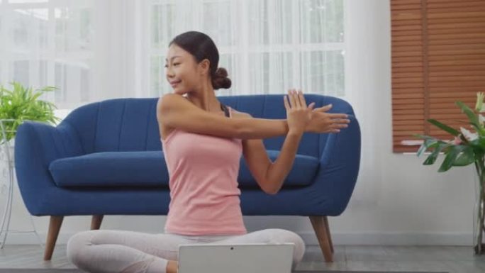 家用数字平板电脑在线学习瑜伽的女性。牛脸姿势，Gomukasana与鹰臂姿势，多莉滑块射击