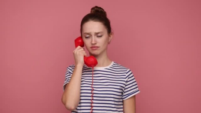女人大声尖叫，手里拿着红色的座机电话，与某人发生冲突。