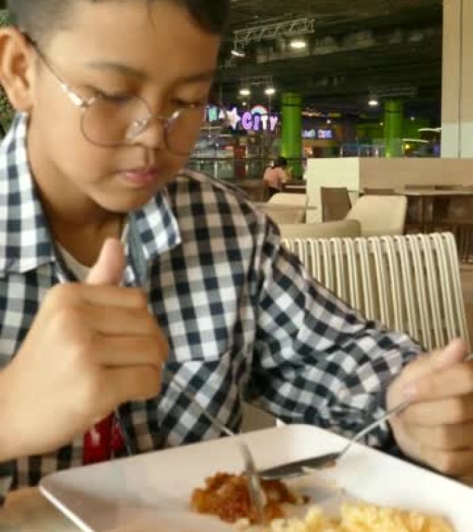 男孩吃美味的鸡肉米饭。