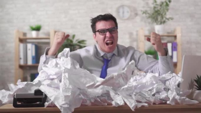 尖叫着富有表现力的办公室工作人员在桌子上的一堆办公室文件中戴着眼镜，缓慢的mo