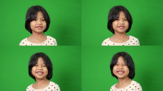 绿色屏幕背景上快乐，微笑和有趣的亚洲儿童女孩的肖像，一个孩子看着相机。学龄前儿童做梦充满能量感觉健康