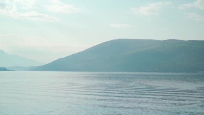 在一个美好的夏日阳光明媚的日子里，美丽的海湾和山脉景色