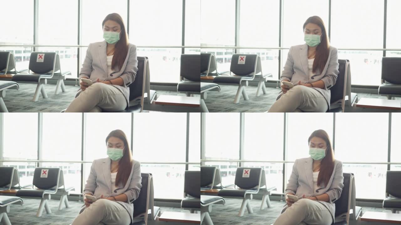 东南亚女商人在国际机场等待航班并使用智能手机