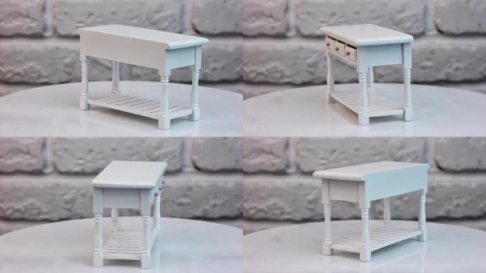 转台上有三个抽屉的玩具桌。玩具屋内部白色雕刻微型桌子。特写。