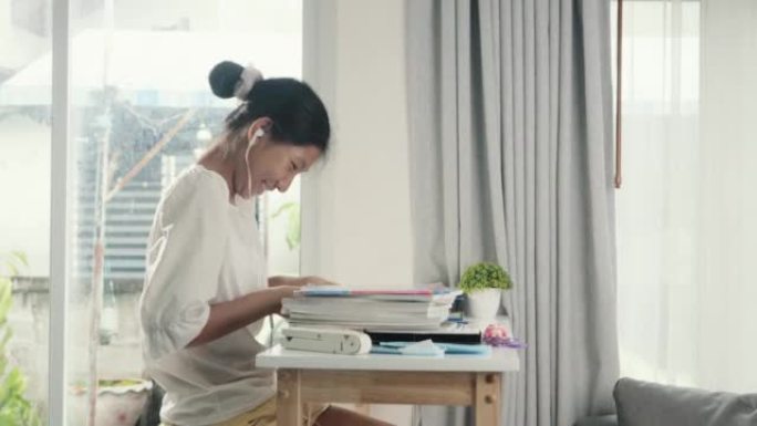 亚洲女孩在家做作业或在靠近窗户的桌杠上写书，教育生活方式理念。
