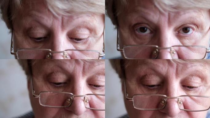 一位老妇人的脸特写。戴眼镜的棕色眼睛的成熟女人。慢动作