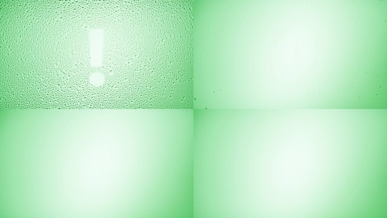 绿色背景上湿玻璃上的感叹号吹落