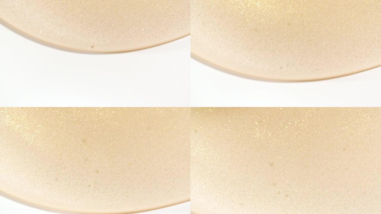 透明黄色化妆品液体凝胶的宏观拍摄，白色表面有气泡向下流动的乳霜。天然有机化妆品，医药。