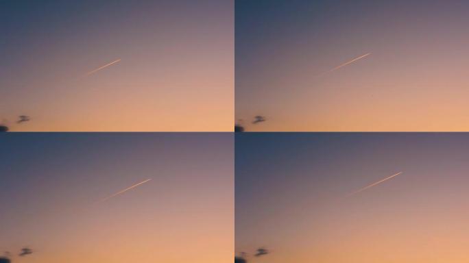 日落时天空中的飞机。飞机上的燃料白色条纹