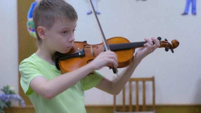 小学生青少年儿童在学校音乐课上拉小提琴。