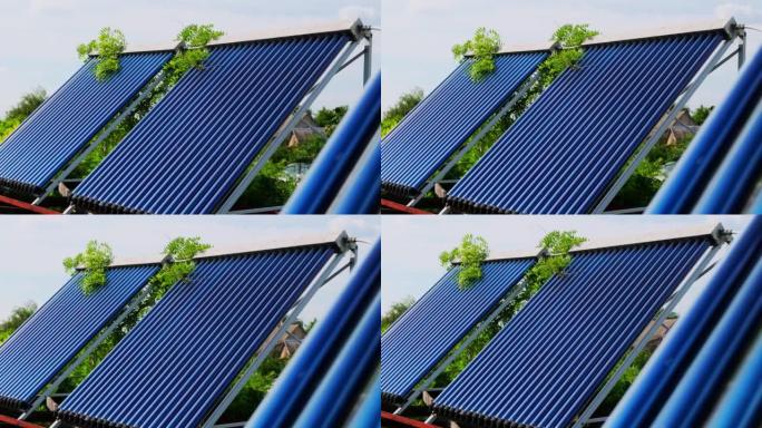 真空集热器是房屋附近的太阳能热水系统。高楼屋顶上的太阳能热水器机组锅炉。蓝天背景与云彩。太阳能热水系