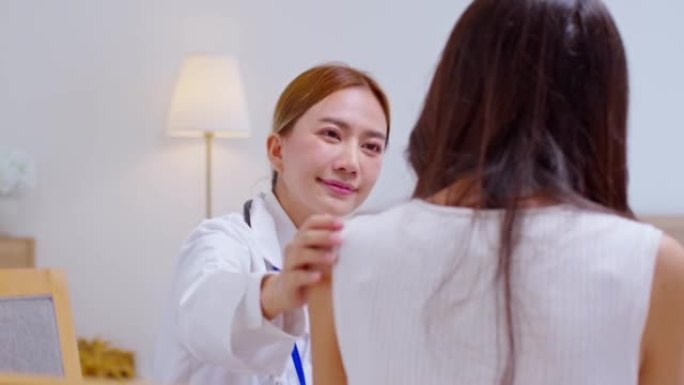 亚洲女医生给医院压力大的女性患者带来希望和鼓励。微笑的女医生触摸病人的肩膀支持照顾和帮助。支持和鼓励
