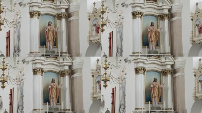 教堂白色内部举手的耶稣基督雕像。带有圣徒的圆柱拱
