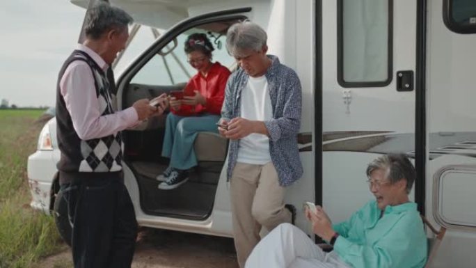露营车汽车之家旁的智能手机上的亚洲华人活跃高级阅读