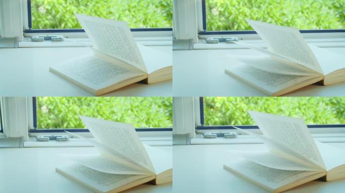 打开躺在窗台上的书，风吹拂着书页，阳光明媚的日子，相机跟踪