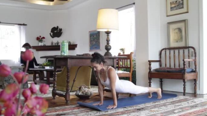 在科罗纳病毒期间，年轻女运动员在家做普拉提、瑜伽和力量训练练习，新型冠状病毒肺炎检疫在客厅的垫子上