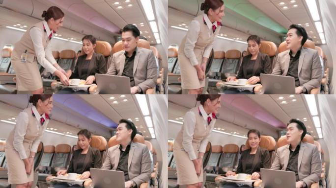 在飞机上，一位友好的亚洲女空姐在与顾客交谈的同时提供食物和饮料。提供航空服务。