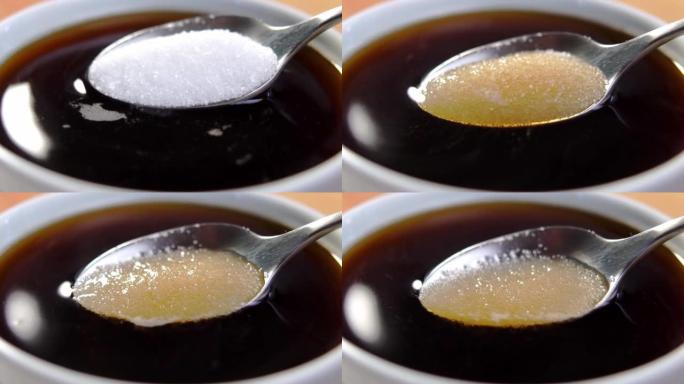 将糖晶体添加并溶解在带有新鲜浓缩咖啡的白色满杯中。全勺特写