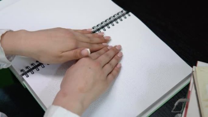 手触摸盲文中的描述。盲文是视力障碍者使用的触觉书写系统