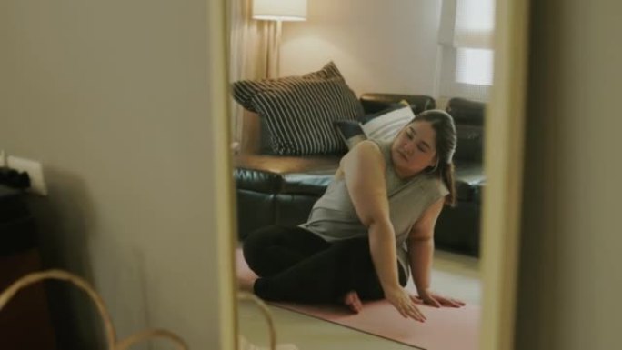 在家瑜伽前开始伸展身体，镜子反射。