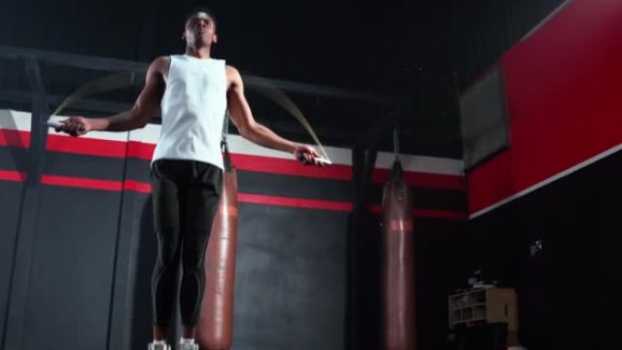 男子在健身房用跳绳锻炼身体。