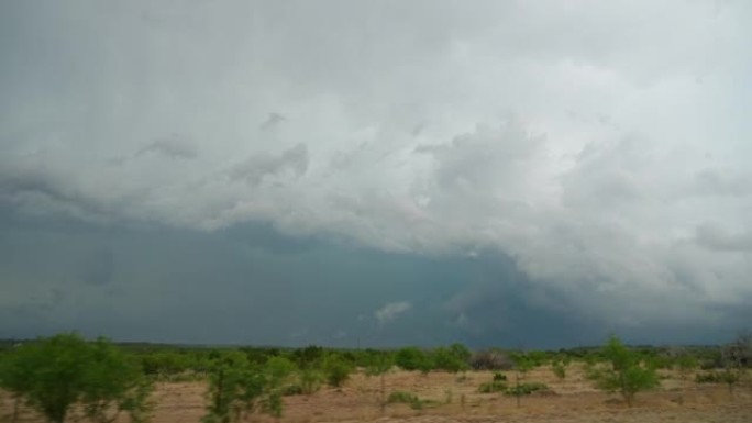 开车穿过德克萨斯州，看着窗外远处的暴风雨