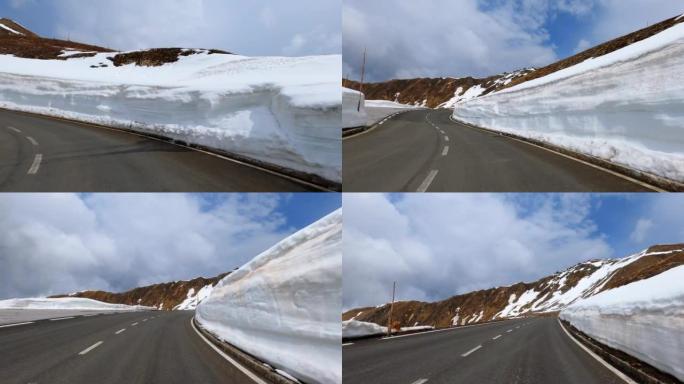 在奥地利阿尔卑斯山的达施泰因的大格洛克纳附近的边缘，驾驶汽车通过高雪块的狭窄曲线的POV
